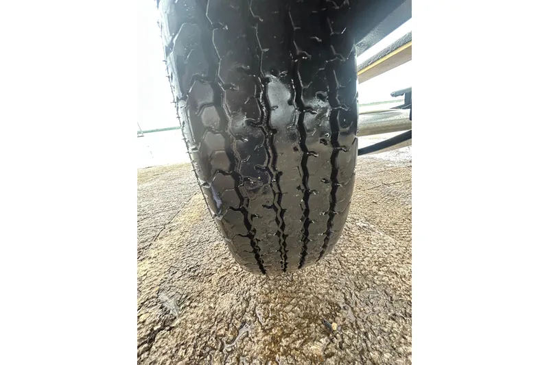 Slide: The Image of Close-up of a wet tire on a 2020 Tracker Pro Team 190 TX boat trailer. - 47