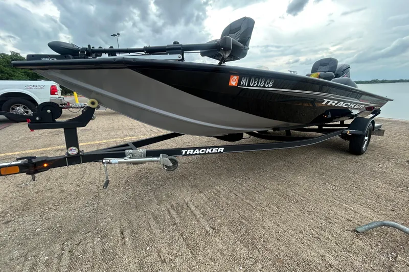 Slide: The Image of 2020 Tracker Pro Team 190 TX boat on trailer, parked near a lake under cloudy skies. - 51