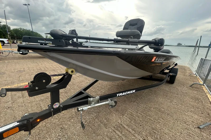 Slide: The Image of 2020 Tracker Pro Team 190 TX boat on trailer by waterfront, featuring Minn Kota motor. - 63