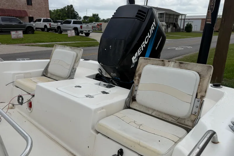 Slide: The Image of 2006 NAUTIC STAR 2100 boat interior with Mercury engine and worn seating. - 11