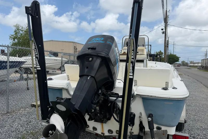 Slide: The Image of 2006 NAUTIC STAR 2100 boat with Mercury 150 engine, parked outdoors. - 12