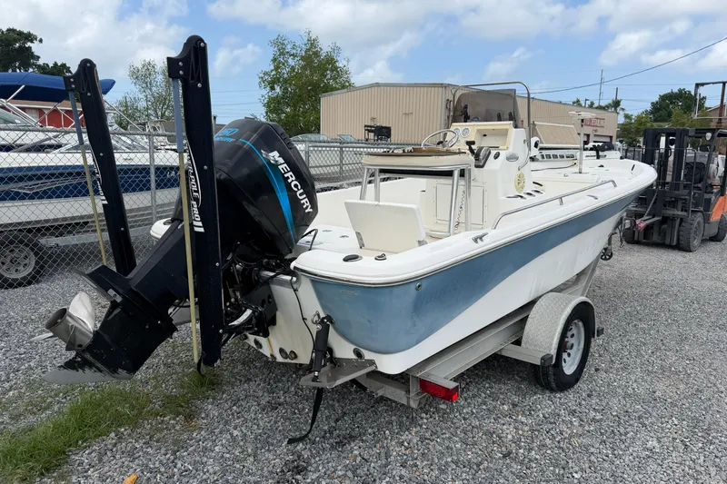 Slide: The Image of 2006 NAUTIC STAR 2100 boat with Mercury outboard motor on trailer, parked outdoors. - 3