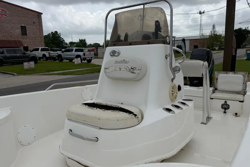 Slide: The Image of 2006 NAUTIC STAR 2100 boat with worn seating and console, parked outdoors. - 7