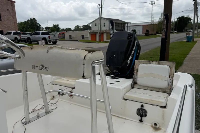 Slide: The Image of 2006 NAUTIC STAR 2100 boat with Mercury engine, parked on a street. - 8