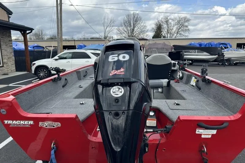 Slide: The Image of 2017 Tracker Pro Guide V-16 SC boat with 60 HP engine, parked outdoors. - 13