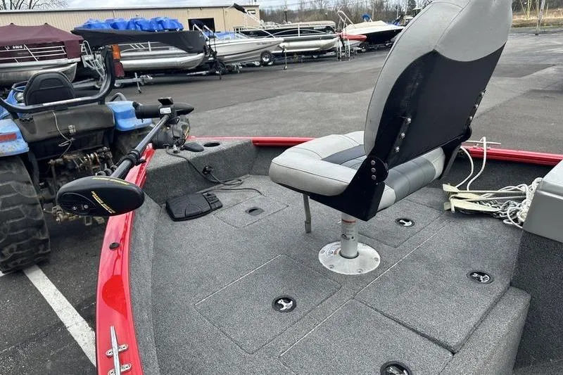 Slide: The Image of 2017 Tracker Pro Guide V-16 SC boat with seating and trolling motor in a parking lot. - 4