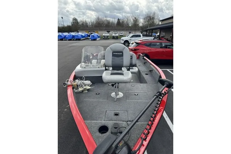 Slide: The Image of 2017 Tracker Pro Guide V-16 SC fishing boat with seating, parked outdoors. - 5
