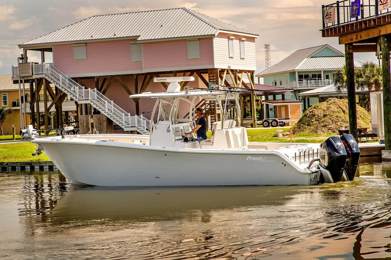 Slide: The Image of 2023 Front Runner 33 Center Console boat on calm water near houses. - 7