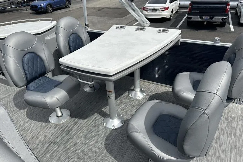 Slide: The Image of 2022 Bennington L 23 L-Bench boat interior with gray seating and table. - 10