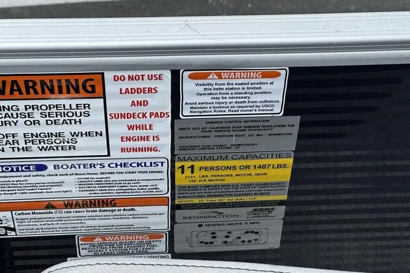 Slide: The Image of Warning labels on a 2022 Bennington L 23 L-Bench boat, detailing safety and capacity. - 12