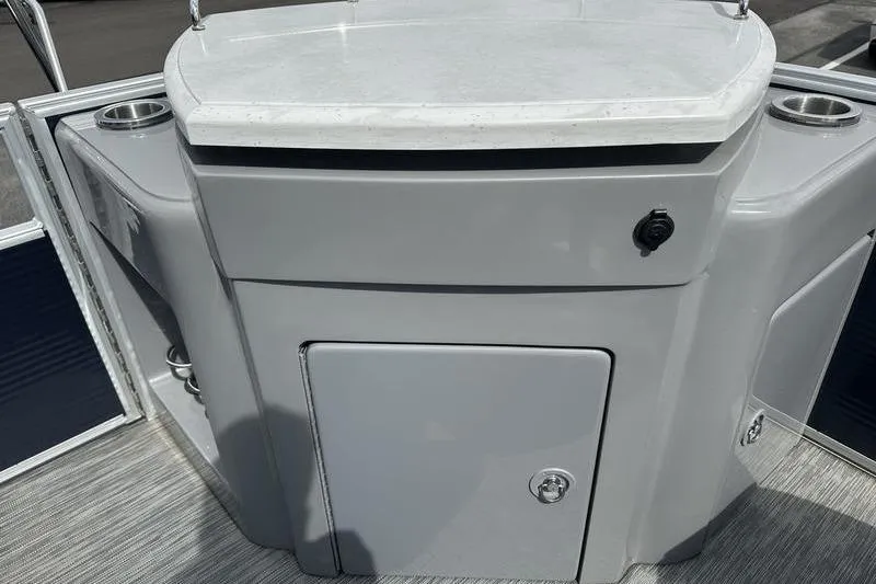 Slide: The Image of 2022 Bennington L 23 L-Bench boat interior with storage compartment and cup holders. - 13