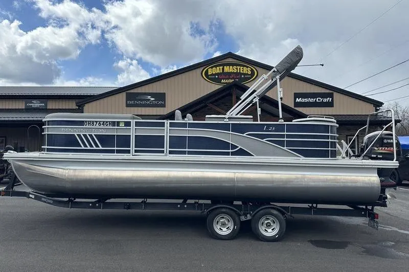 Slide: The Image of 2022 Bennington L 23 L-Bench pontoon boat on trailer at dealership. - 17