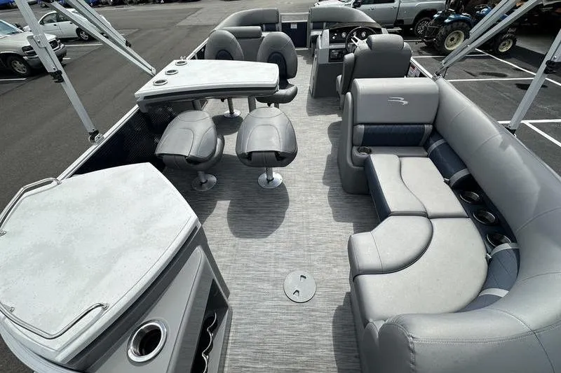 Slide: The Image of 2022 Bennington L 23 L-Bench pontoon boat interior with gray seating and table setup. - 18