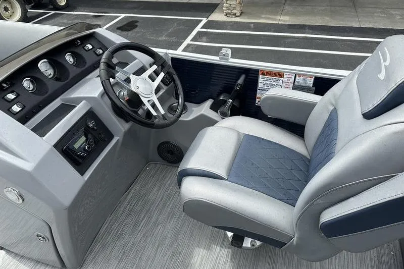 Slide: The Image of Captain's seat and helm of 2022 Bennington L 23 L-Bench pontoon boat, featuring modern controls. - 7