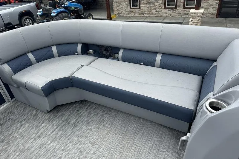 Slide: The Image of 2022 Bennington L 23 L-Bench boat interior with gray and blue seating. - 9
