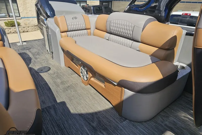 Slide: The Image of 2024 Avalon Excalibur Quad Lounge Windshield boat interior with tan and gray seating. - 104