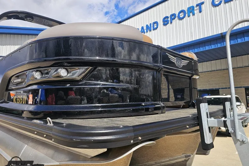 Slide: The Image of 2024 Avalon Excalibur Quad Lounge boat at dealership, showcasing sleek black design and modern features. - 14