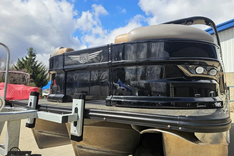 Slide: The Image of 2024 Avalon Excalibur Quad Lounge Windshield pontoon boat on trailer under blue sky. - 18