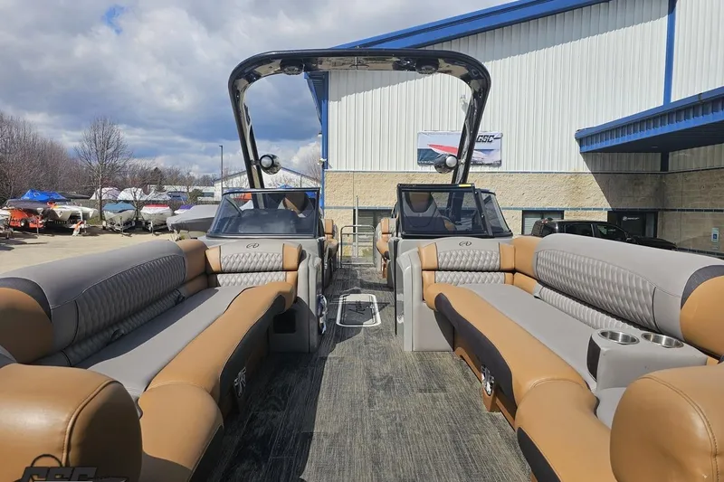 Slide: The Image of 2024 Avalon Excalibur Quad Lounge Windshield boat with luxurious seating, docked outdoors. - 20