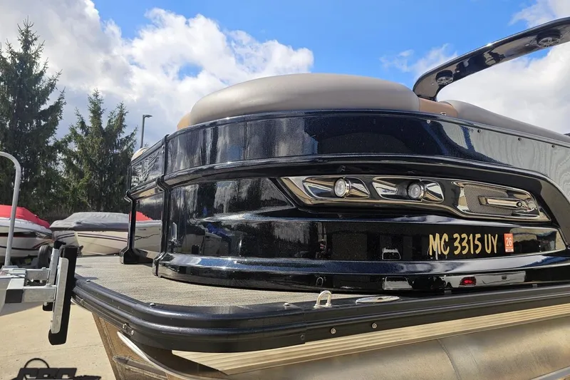 Slide: The Image of 2024 Avalon Excalibur Quad Lounge Windshield boat, sleek design, docked under blue sky. - 23