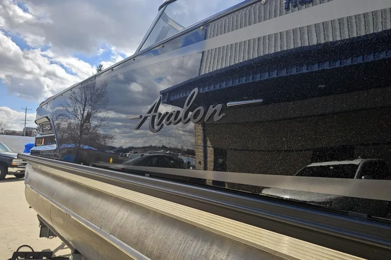 Slide: The Image of 2024 Avalon Excalibur Quad Lounge boat with sleek black exterior and windshield. - 33