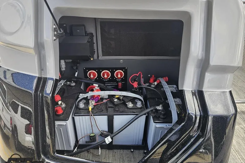 Slide: The Image of 2024 Avalon Excalibur Quad Lounge Windshield boat battery compartment with wiring and switches. - 46