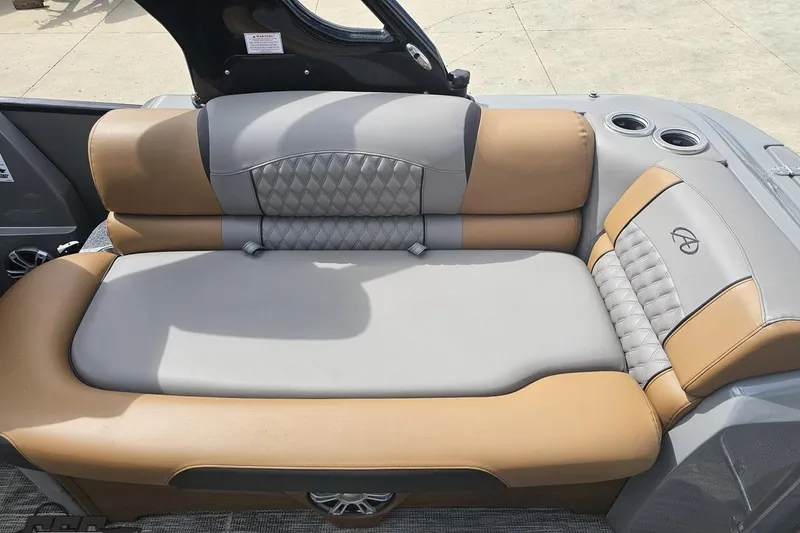 Slide: The Image of Luxurious seating on 2024 Avalon Excalibur Quad Lounge Windshield boat, featuring tan and gray upholstery. - 56