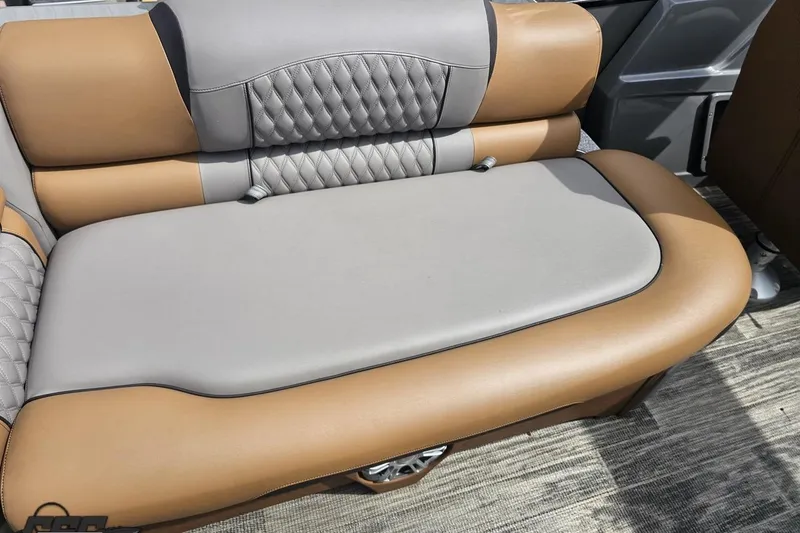 Slide: The Image of 2024 Avalon Excalibur Quad Lounge Windshield boat seat, featuring luxurious tan and gray upholstery. - 61