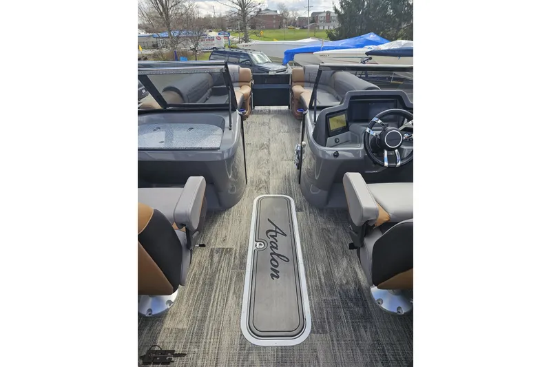 Slide: The Image of 2024 Avalon Excalibur Quad Lounge Windshield boat interior with modern seating and steering console. - 62