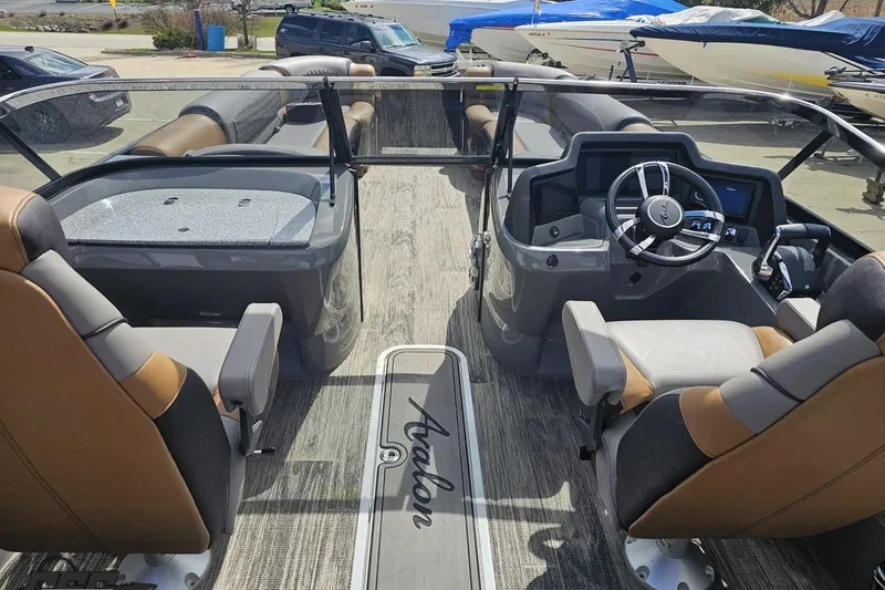 Slide: The Image of 2024 Avalon Excalibur Quad Lounge Windshield boat interior with modern helm and seating. - 63