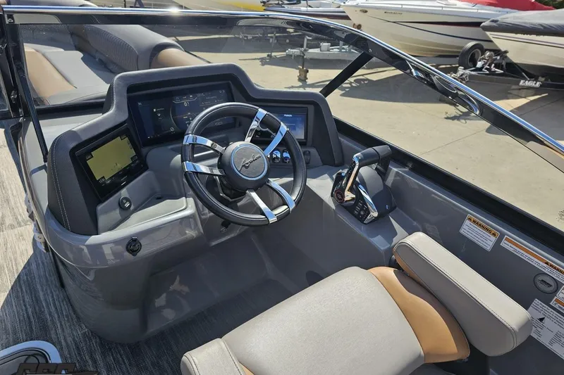 Slide: The Image of 2024 Avalon Excalibur Quad Lounge boat dashboard with modern controls and steering wheel. - 78
