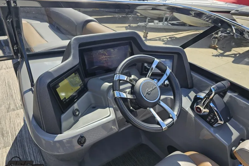 Slide: The Image of 2024 Avalon Excalibur Quad Lounge boat dashboard with steering wheel and digital displays. - 79