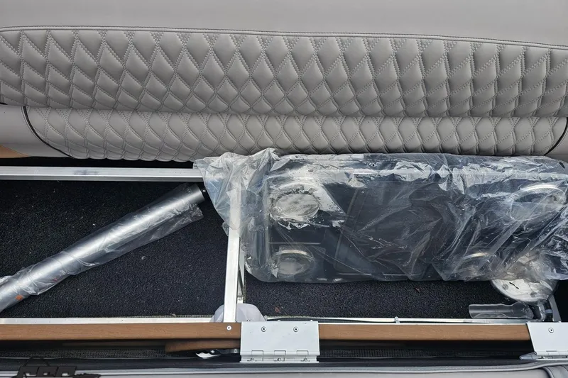 Slide: The Image of 2024 Avalon Excalibur Quad Lounge storage compartment with wrapped components and quilted upholstery. - 95