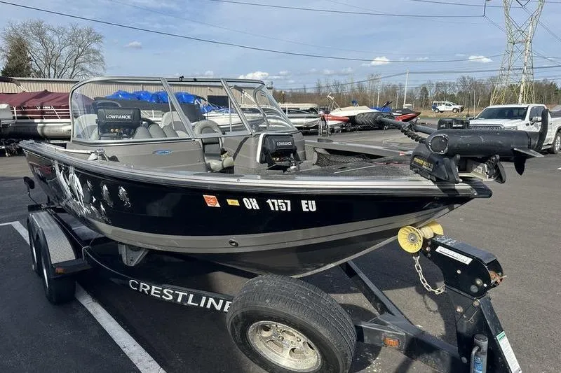 Slide: The Image of 2011 Crestliner 1850 Fish Hawk SC boat on trailer, parked outdoors. - 3