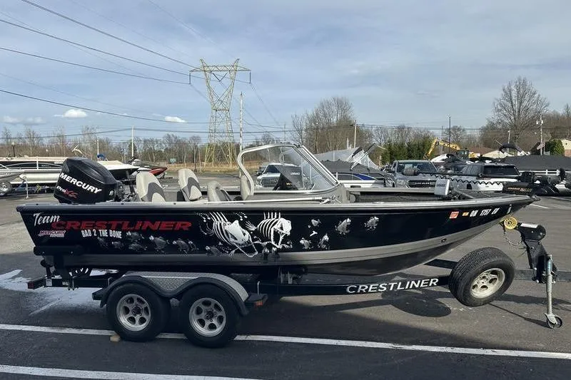 Slide: The Image of 2011 Crestliner 1850 Fish Hawk SC boat on trailer, featuring sleek design and graphics. - 5