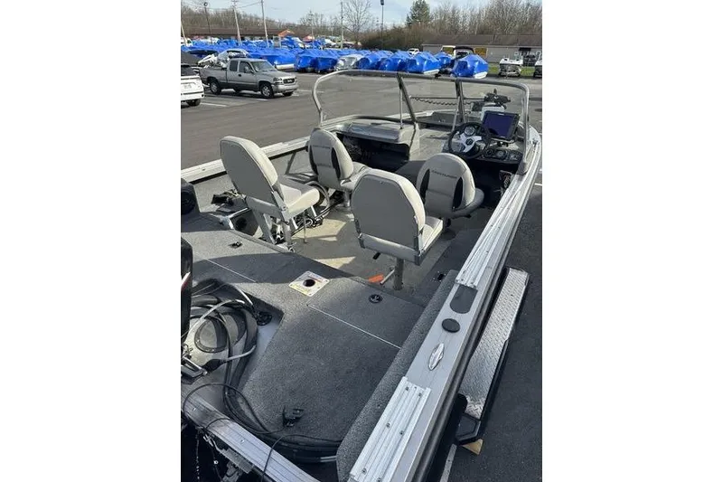 Slide: The Image of 2011 Crestliner 1850 Fish Hawk SC boat interior with seating and dashboard in a parking lot. - 8