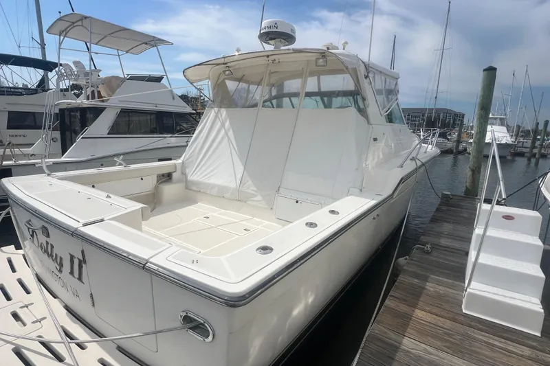 The Image of 1996 Tiara Yachts 4300 Open docked at marina, showcasing spacious deck and sleek design. - 0