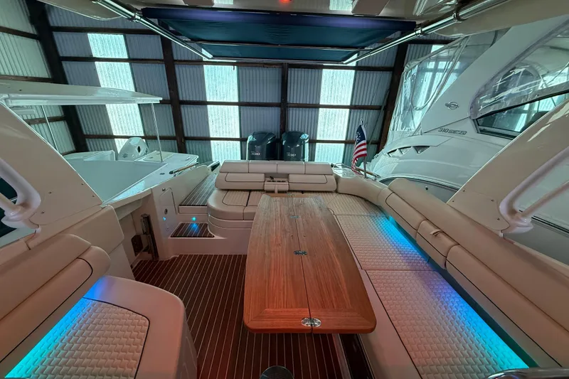 Slide: The Image of 2021 Chris-Craft Launch 31 GT interior with elegant seating and wooden table in a boat garage. - 19