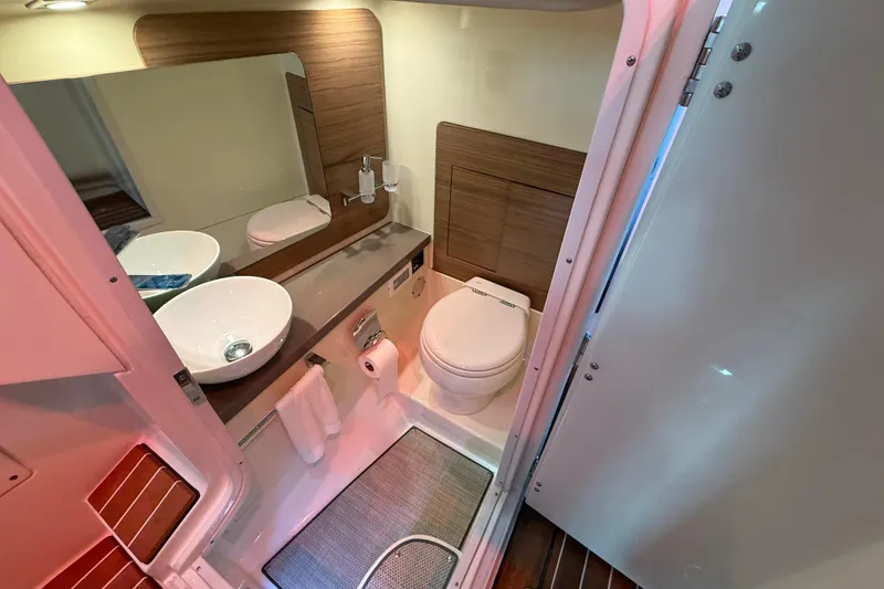 Slide: The Image of 2021 Chris-Craft Launch 31 GT bathroom with modern sink, toilet, and wood accents. - 33