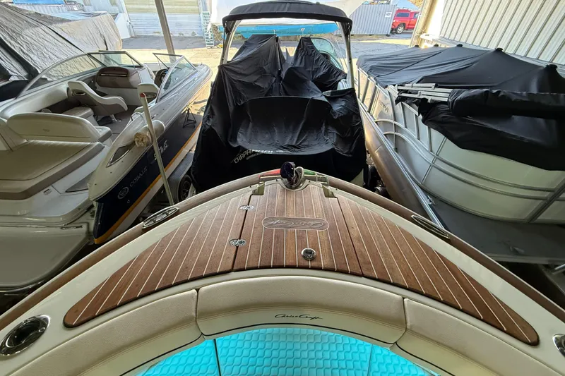 Slide: The Image of 2021 Chris-Craft Launch 31 GT boat in storage, surrounded by other covered boats. - 6