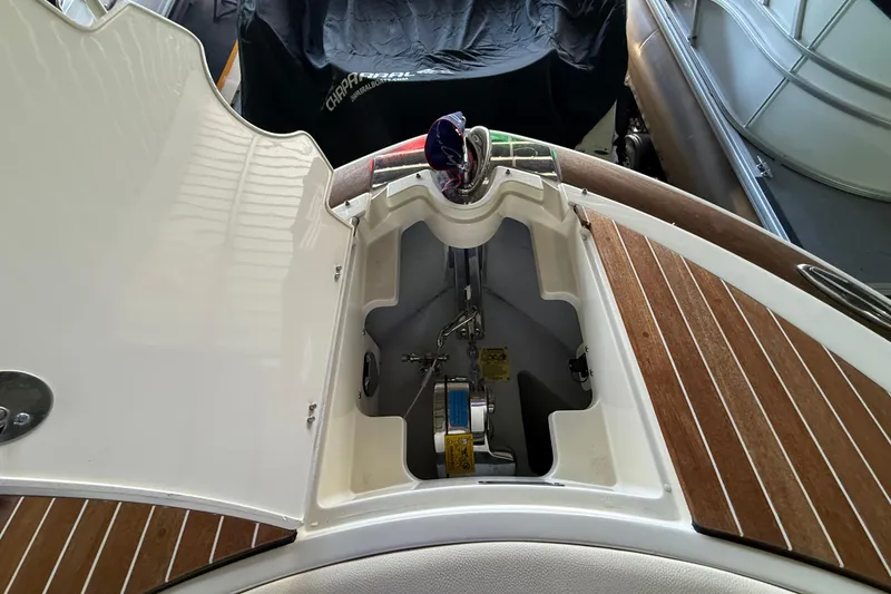 Slide: The Image of 2021 Chris-Craft Launch 31 GT anchor compartment with open hatch, showcasing wood deck details. - 7