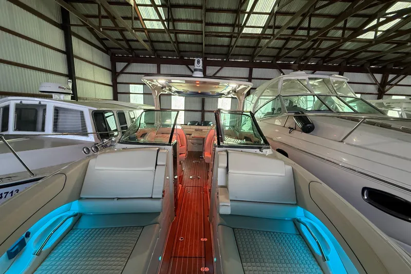 Slide: The Image of 2021 Chris-Craft Launch 31 GT in a boat storage facility, featuring elegant interior lighting. - 8