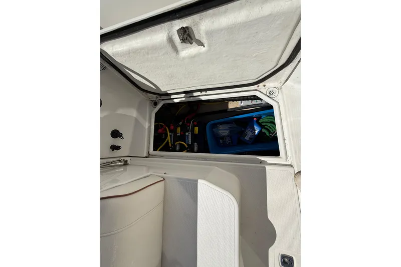 Slide: The Image of Open storage compartment in a 2016 Cutwater 24 boat, showing interior equipment and supplies. - 13