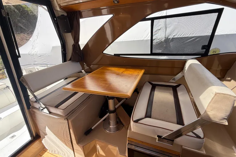 Slide: The Image of Interior of a 2016 Cutwater 24 boat with a cozy dining area and wooden table. - 19