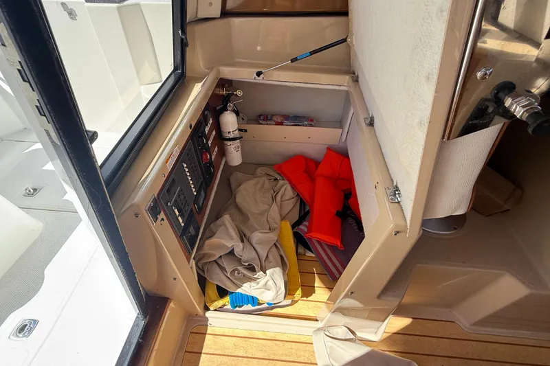 Slide: The Image of Interior storage of a 2016 Cutwater 24 boat with safety equipment and fire extinguisher. - 20