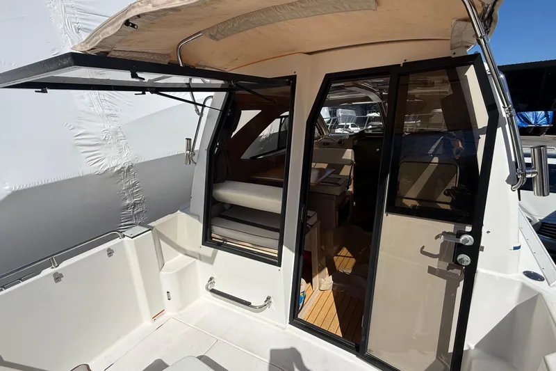 Slide: The Image of 2016 Cutwater 24 boat interior with open cabin door and seating area. - 21