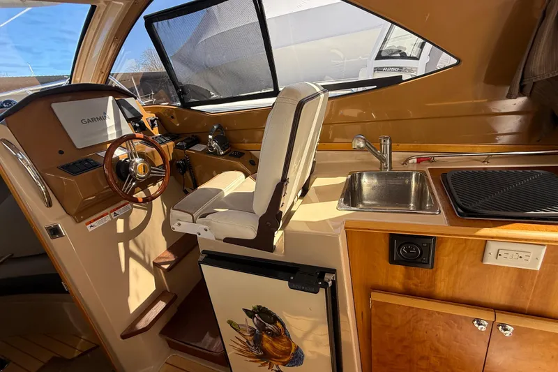 Slide: The Image of Interior of a 2016 Cutwater 24 boat with helm, sink, and kitchenette. - 24