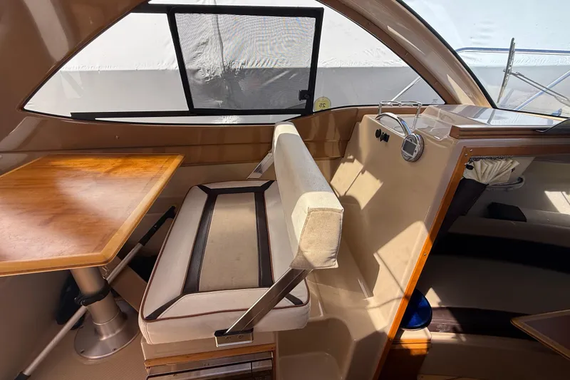 Slide: The Image of Interior of a 2016 Cutwater 24 boat with seating and wooden table. - 25