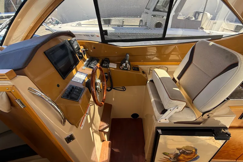 Slide: The Image of Interior of a 2016 Cutwater 24 boat, featuring a steering wheel and navigation controls. - 32