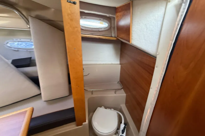 Slide: The Image of 2016 Cutwater 24 boat interior with compact bathroom and wooden accents. - 37